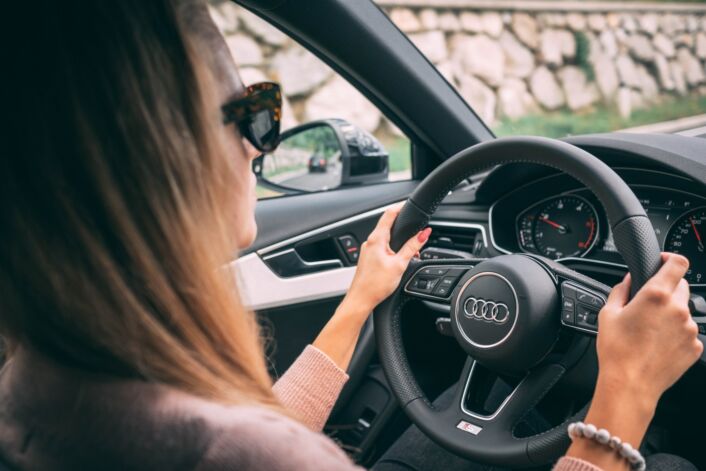 A woman driving her car, after using our tips for buying a car
